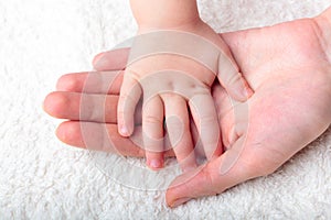 Mother's hand holding baby's hand