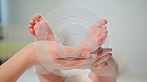 Mother`s Hand Stroking Newborn`s Baby Feet