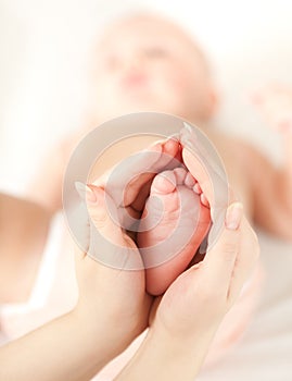 Mother's hands carefully keep baby's foot