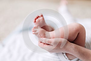 Mother`s hands carefully keeping baby`s foot with tenderness