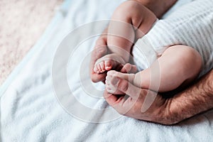 Mother`s hands carefully keeping baby`s foot with tenderness