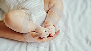 Mother`s hands carefully keeping baby`s foot with tenderness