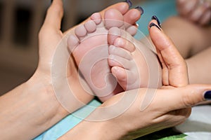 Mother`s hands holding tiny baby feet