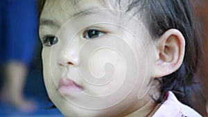 A mother`s hands using a cotton swab to clean her little Asian baby girl`s ear canals