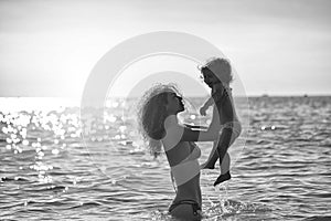 Mother`s love. Woman in bikini with child