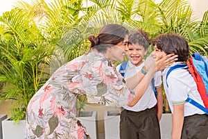 Mother saying goodbye to her children at school