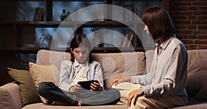 Mother Scolding Son Playing on Phone on Sofa in the Living Room