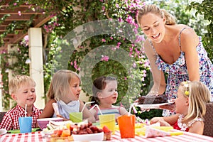 Mother Serving Birthday Cake To Group Of Children