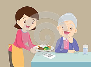 Mother serving food to elderly woman