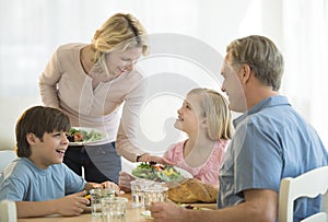 Mother Serving Food To Family At Table