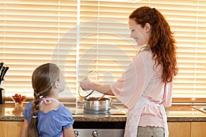 Mother showing her daughter what shes cooking