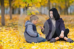 Mother showing son something in her hand in park.