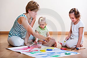 Mother and siblings painting with paint
