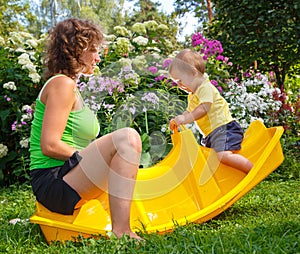 Mother sitting with her son on baby swing