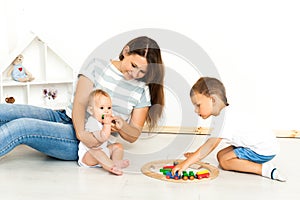 Mother Sitting With kids playing game Indoors