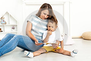 Mother Sitting With Son Reading Story Indoors