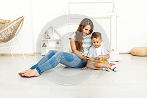 Mother Sitting With Son Reading Story Indoors