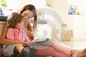 Mother Sitting With Son Reading Story Indoors