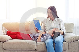 Mother sitting with son reading story indoors