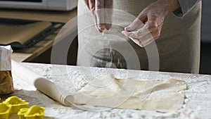 Mother slowly adding flour to dough making correct consistency, slow-motion