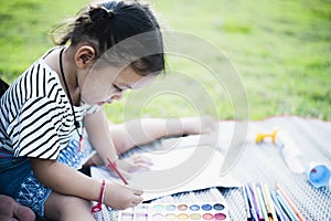 Mother with small child painting in the garden on the lawn Mother and daughter drawing pictures of nature