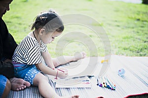 Mother with small child painting in the garden on the lawn Mother and daughter drawing pictures of nature