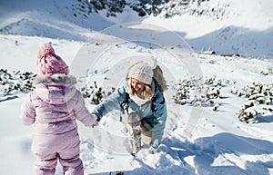 Matka s malou dcérou na prechádzke v snehu v zimnej prírode, koncept dovolenky.