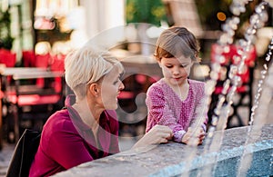 Mother with small daugther having fun outdoors in town.