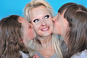 A mother smiles as she receives a kiss on the cheek