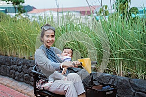 Mother smiles holding her baby while driving a buggy car