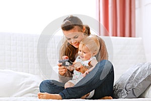 Mother and smiling baby looking photos in camera