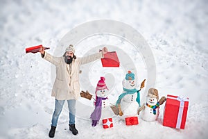 Mother snow-woman, father snow-man and kid wishes merry Christmas and Happy New Year. Happy snow man and bearded man on
