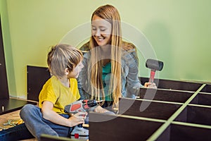 Mother and son assembling furniture. Boy helping his mom at home. Happy Family concept