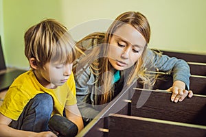 Mother and son assembling furniture. Boy helping his mom at home. Happy Family concept