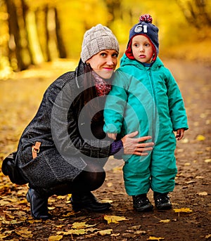 Mother with son in autumn peach garden