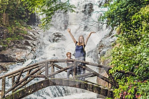 Mother and son in the background of beautiful cascading Datanla waterfall In the mountain town Dalat, Vietnam