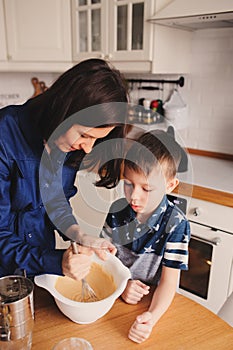 Mother and son baking cake in the kitchen. Lifestyle casual capture of family cooking