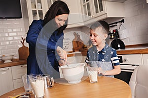 Mother and son baking cake in the kitchen. Lifestyle casual capture of family cooking