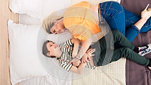 Mother with son on bed, mother and son having fun