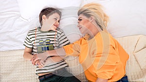 Mother with son on bed, mother and son having fun