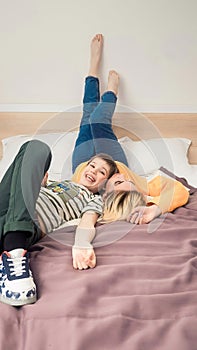Mother with son on bed, mother and son having fun