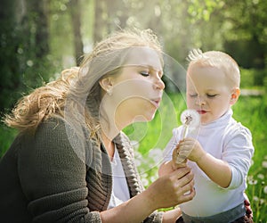 Mother and son blowing on a dandelion