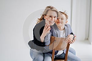 A mother with son in blue clothes having fun and poses for a photo shoot