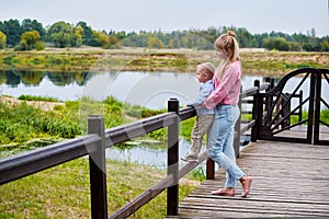 The mother and son on the bridge.mother with baby son standing outdoors.