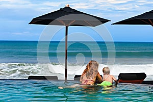 Mother with son chilling in beach swimming pool