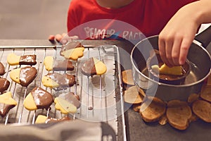 Mother and son cooking cookies with chocolate at home