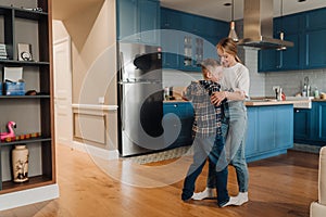 Mother and son dancing while spending fun time together