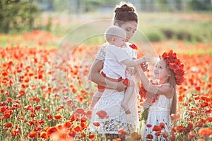 Mother, son and daughter in a field of red poppies