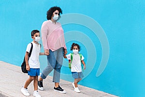 Mother with son and daughter going back to school wearing face masks - Coronavirus lifestyle and family concept - Main focus on