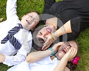 Mother, Son, and Daughter Lauging Outside in the Grass